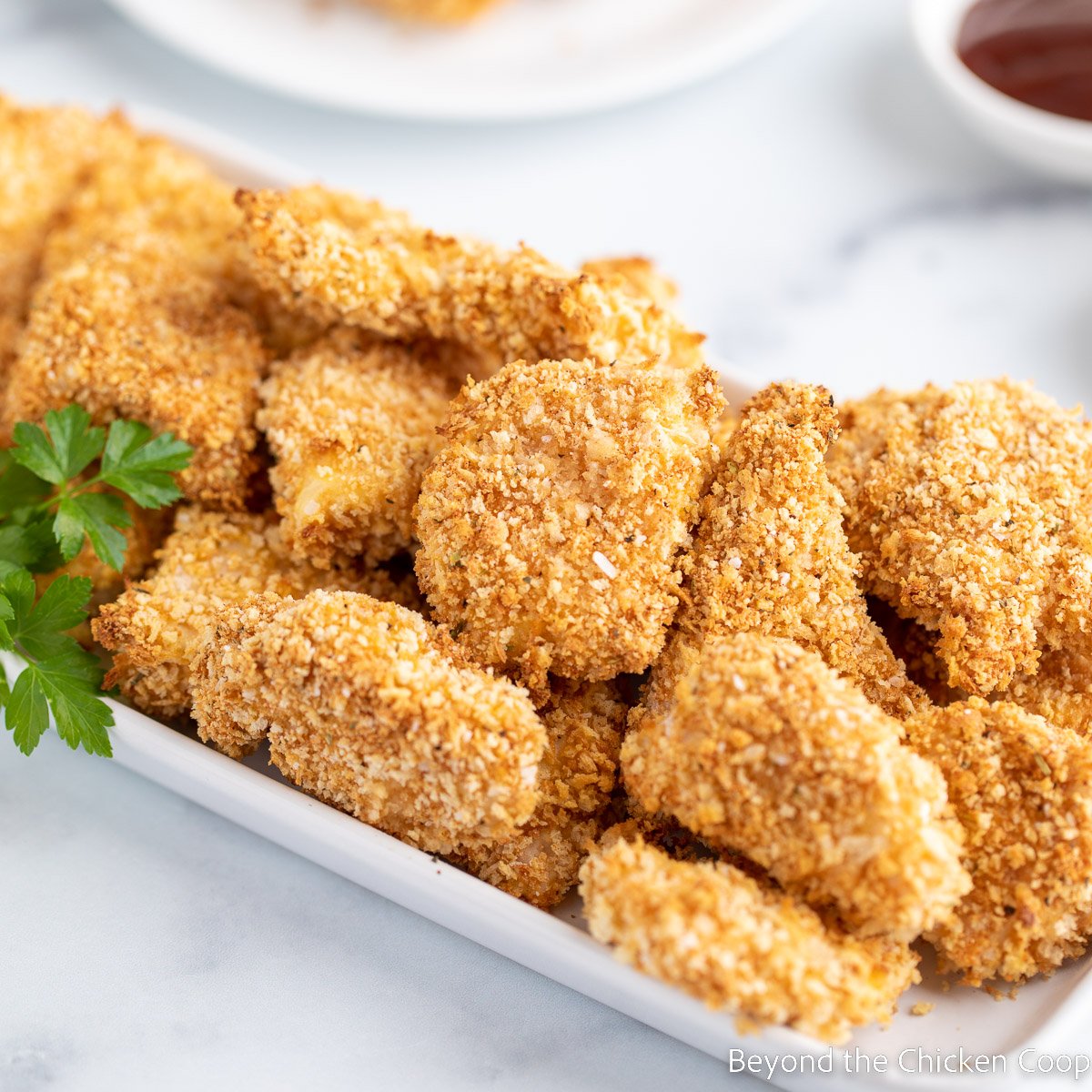 Chicken nuggets on a white platter. 