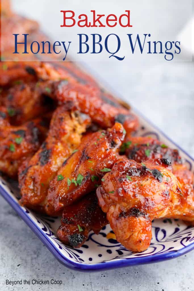 Chicken wings with a sauce on a blue and white platter.