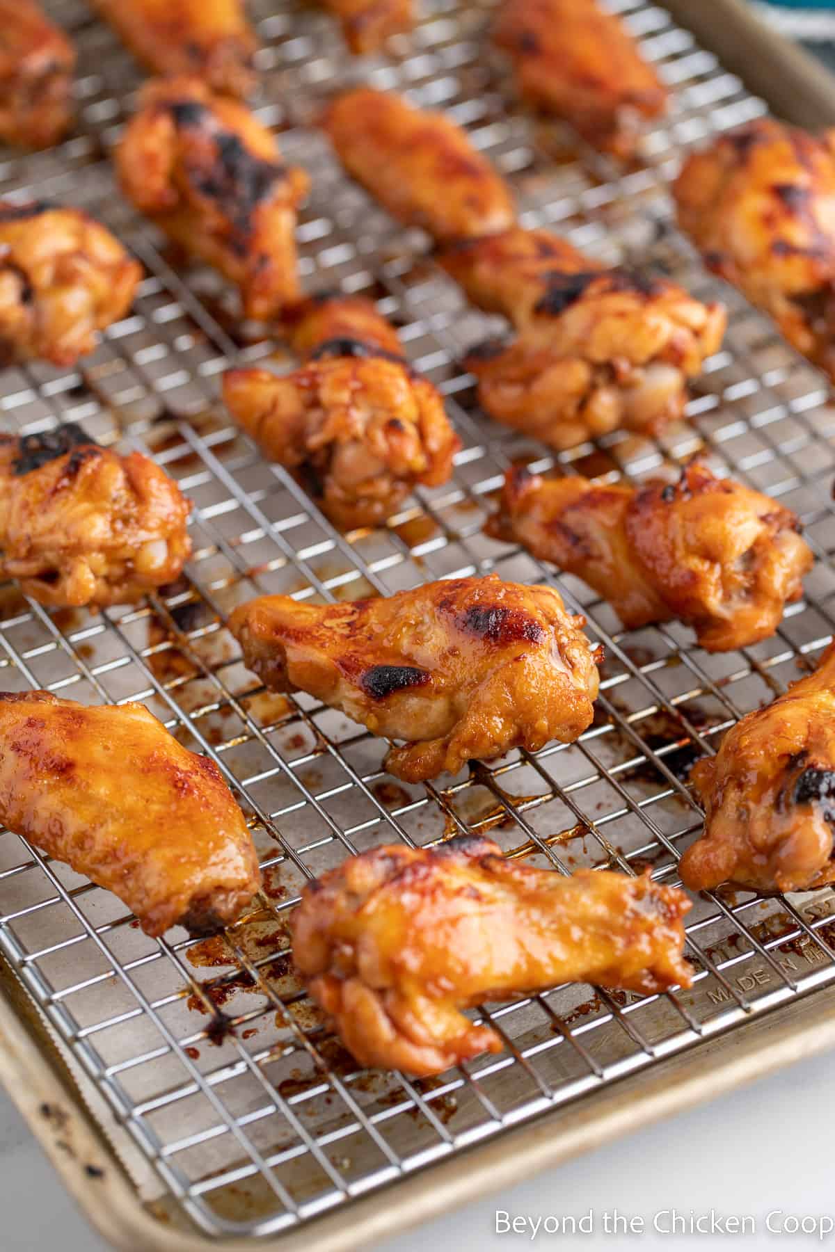 Baked chicken wings on a baking rack.