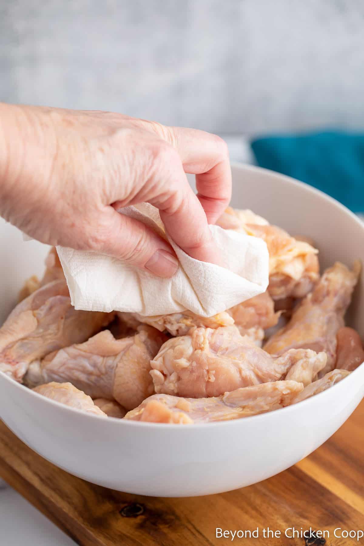 Drying chicken wings with a paper towel. 