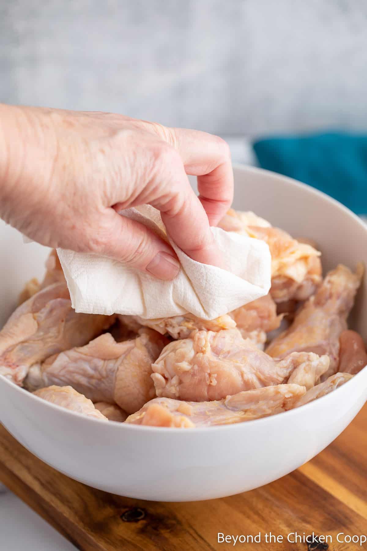 Drying chicken wings with a paper towel.