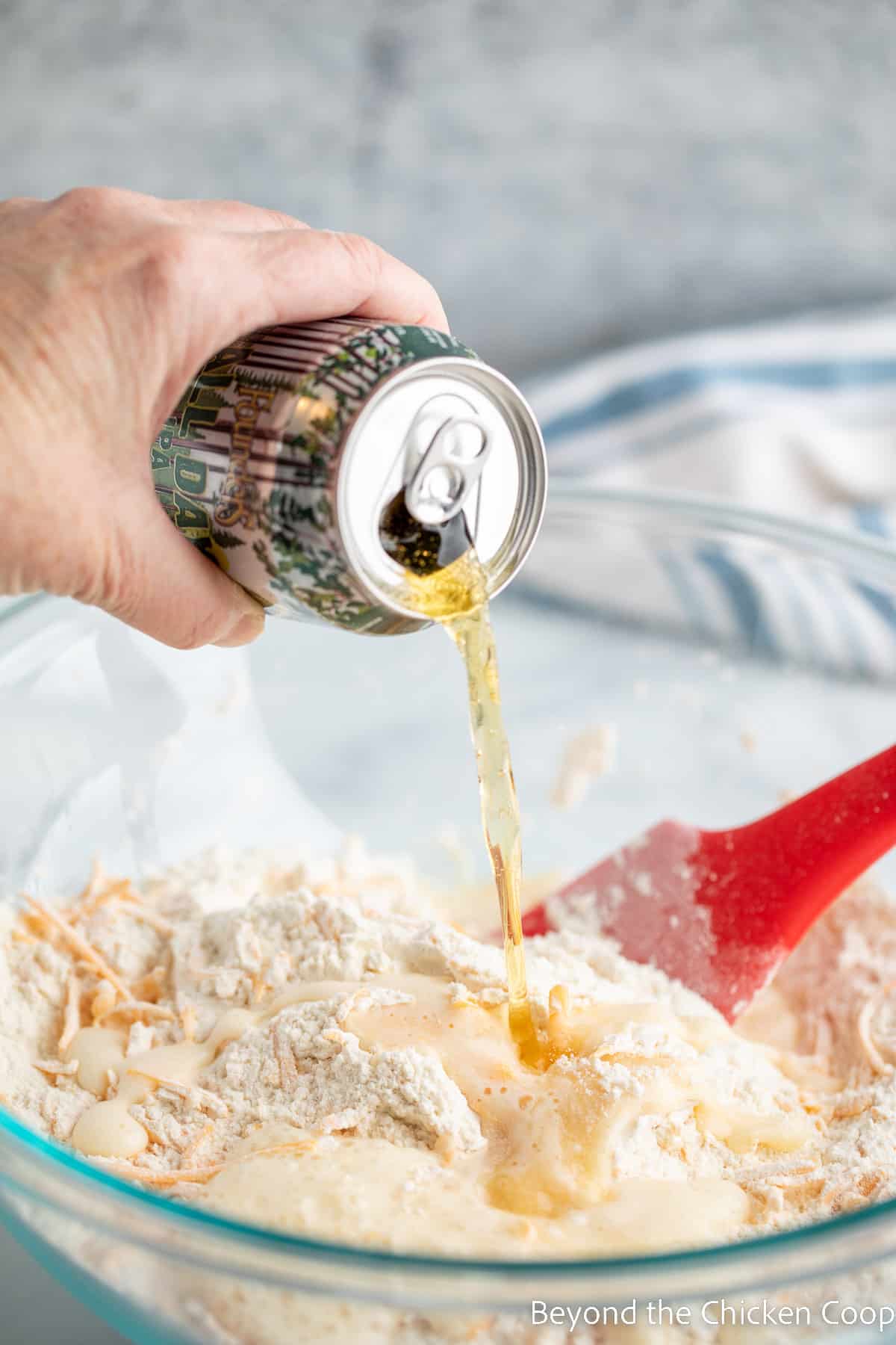 Pouring a beer into a bowl of flour. 