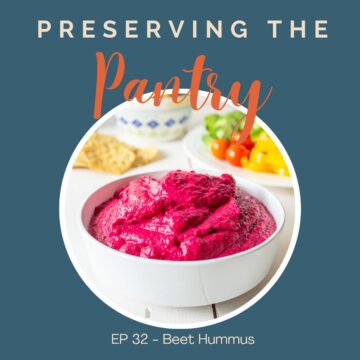 A white bowl filled with a bright pink hummus.