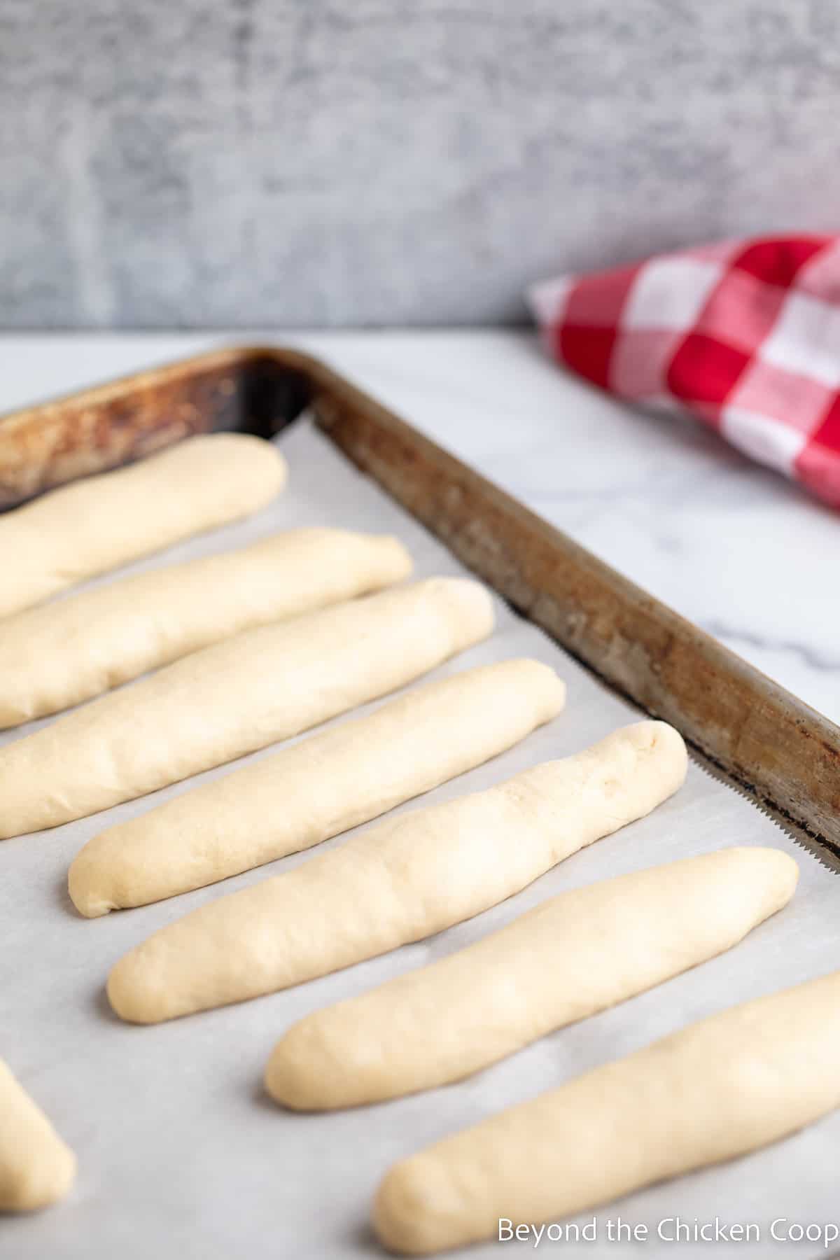 Shaped bread dough on a baking sheet. 