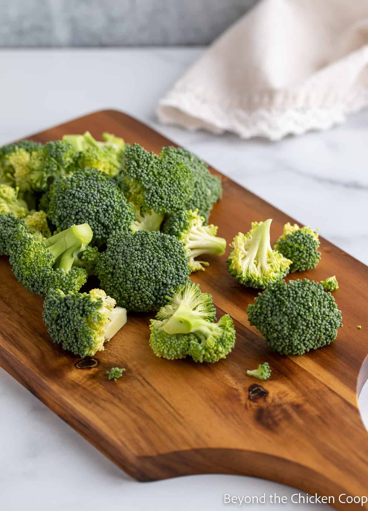 Cut broccoli on a cutting board.