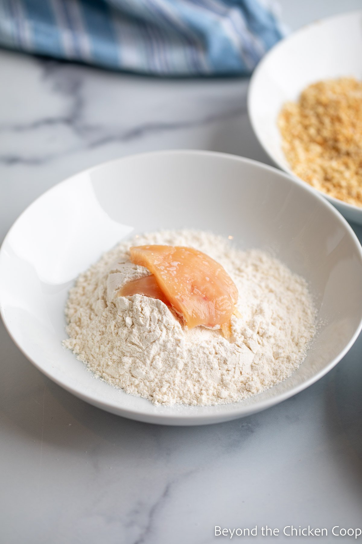 Dredging chicken in flour. 