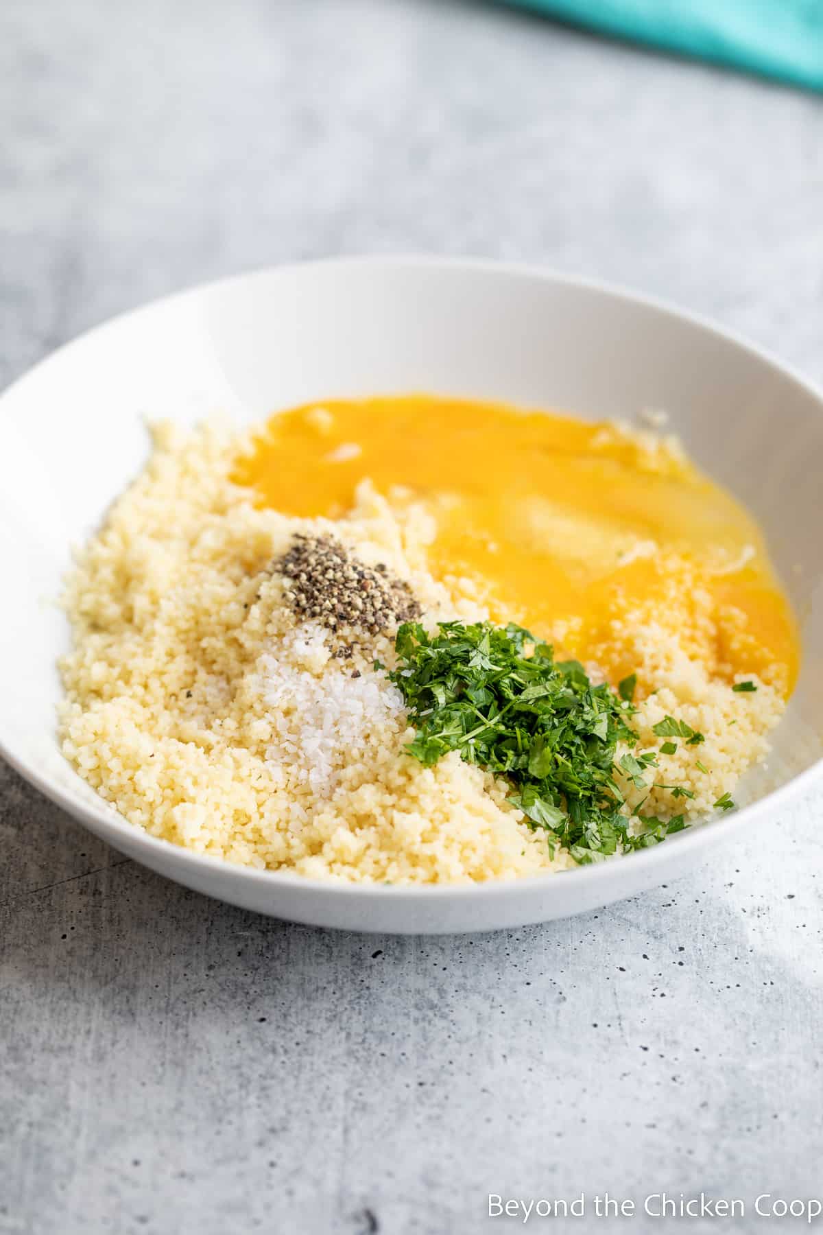 Mixing couscous with eggs and herbs. 