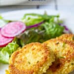 Couscous patties on a plate with a salad.