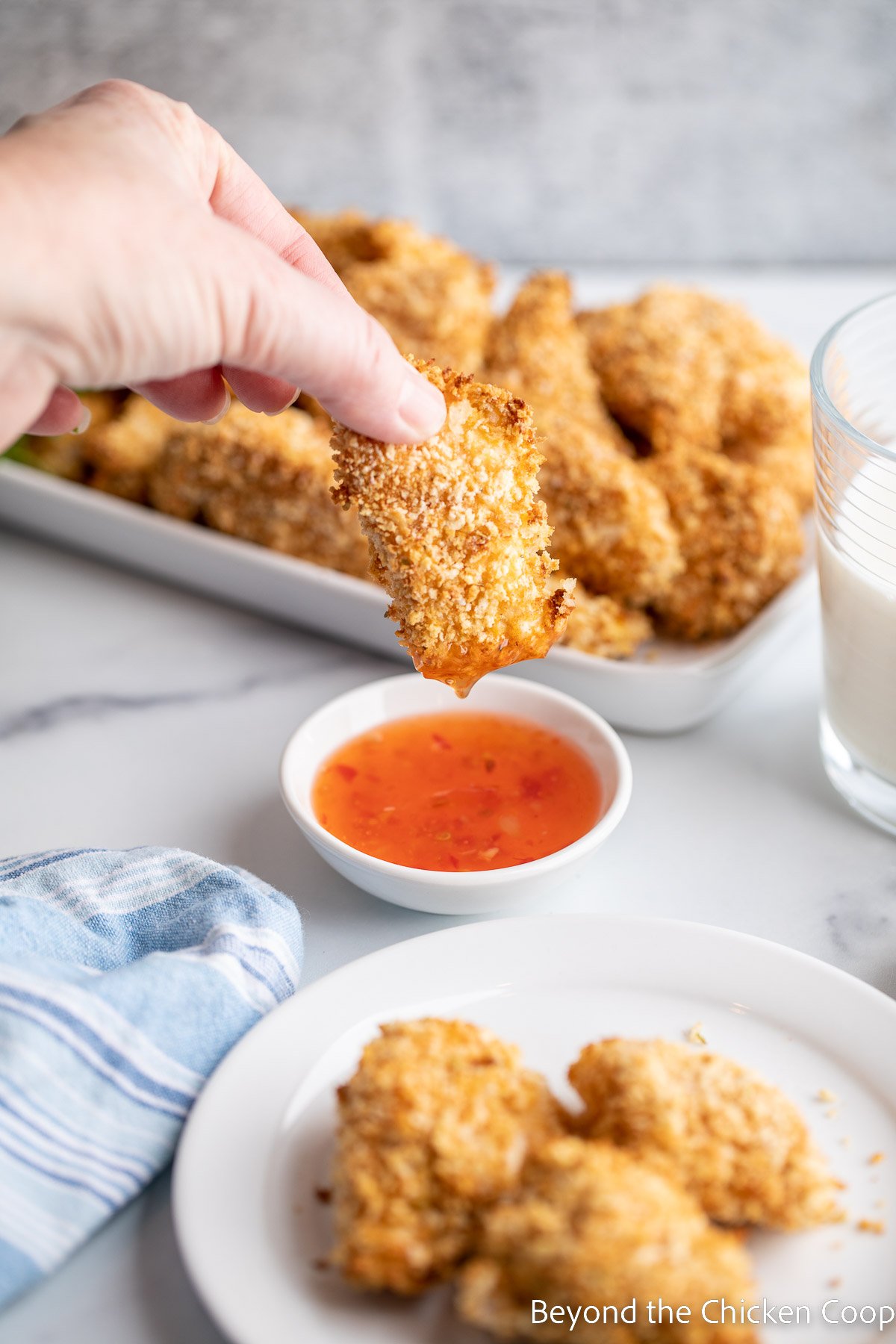 Dipping a chicken nugget into a sauce. 