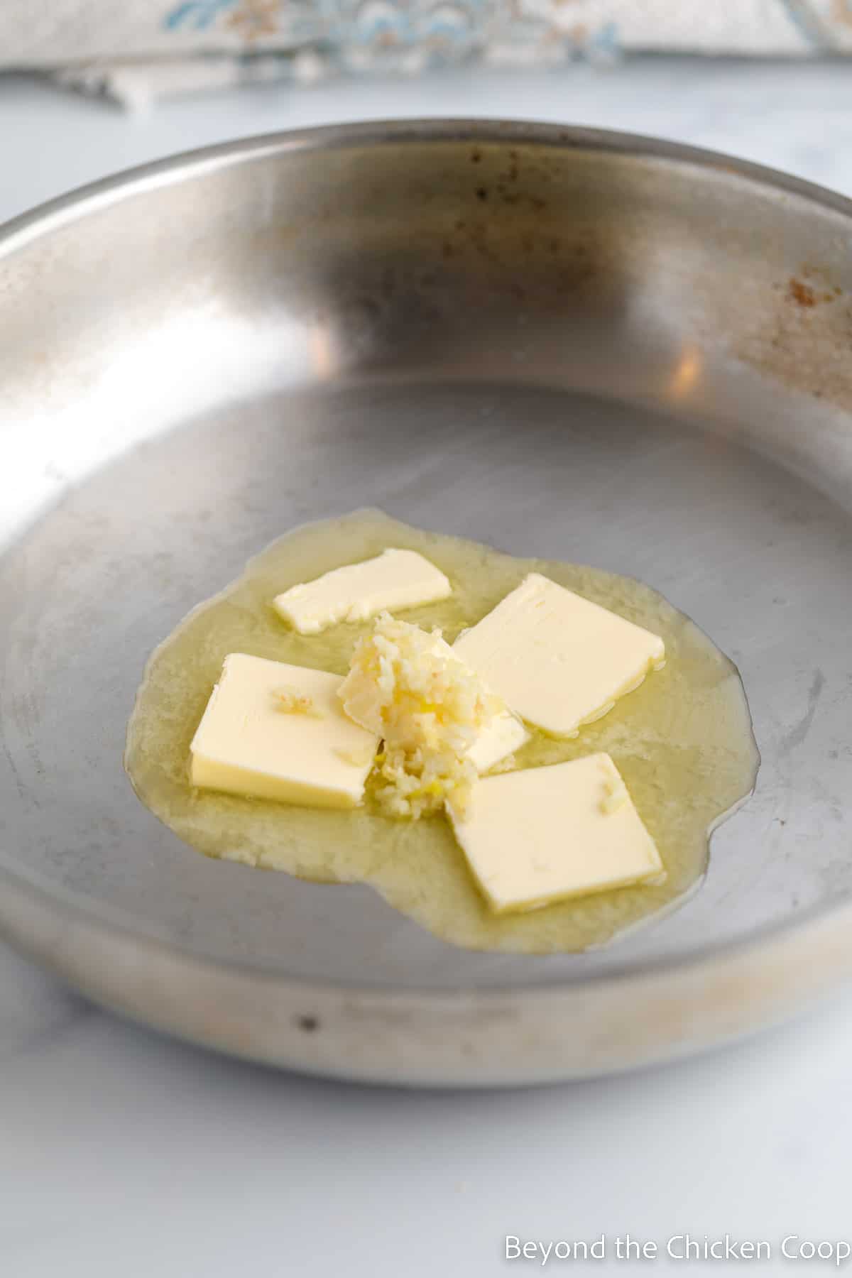 Butter melting in a pan with garlic.