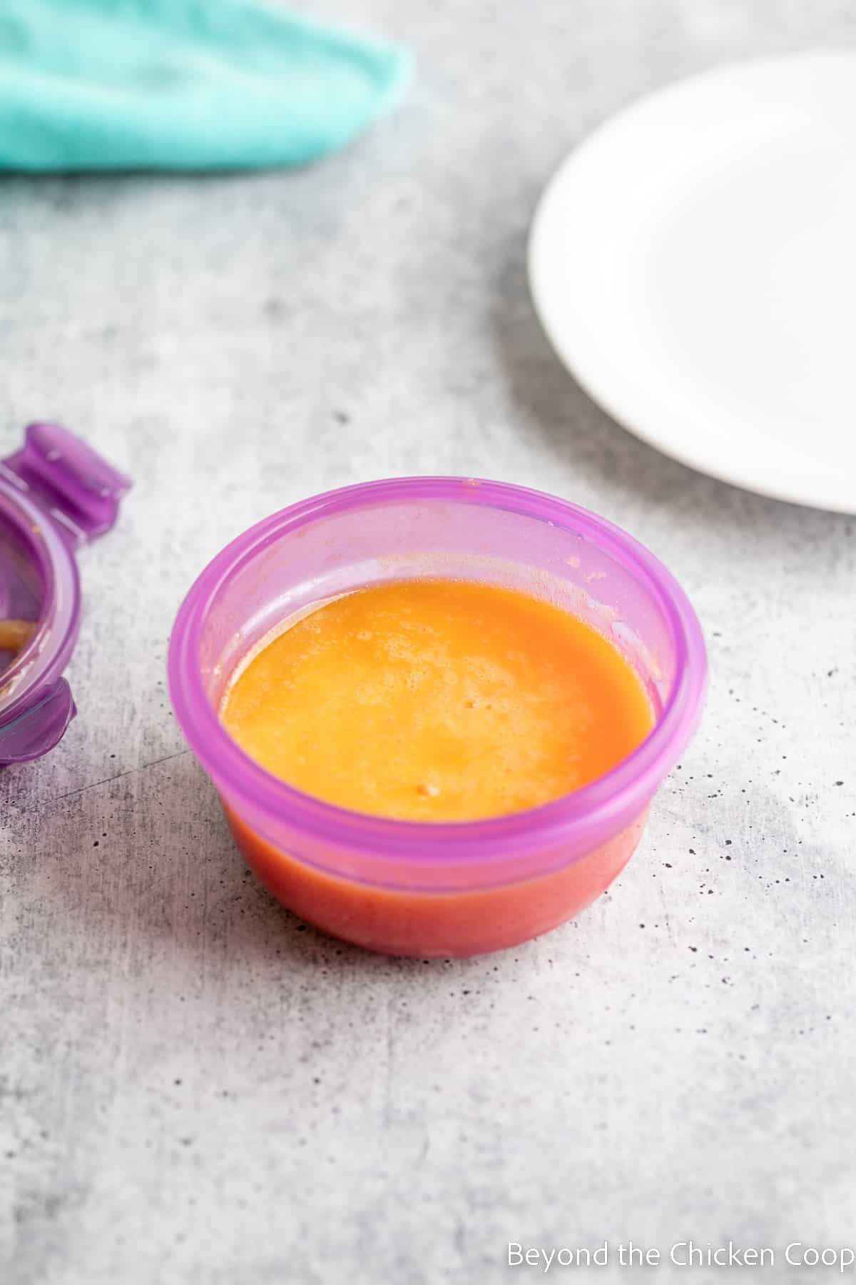 Thawed scrambled eggs in a purple container. 