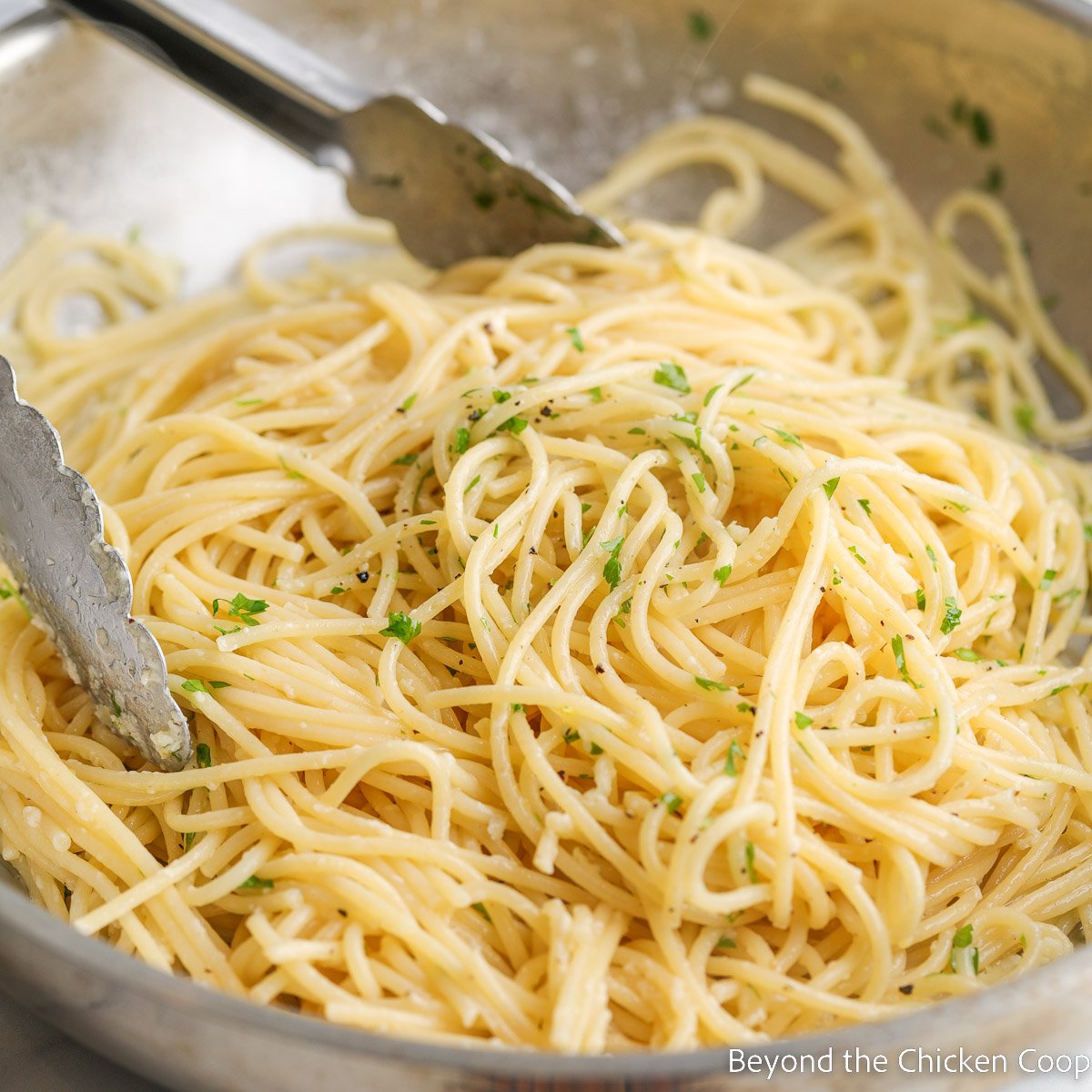 Pasta sprinkled with parsley in a pan.