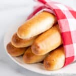 A bundle of breadsticks wrapped in a red and white napkin.