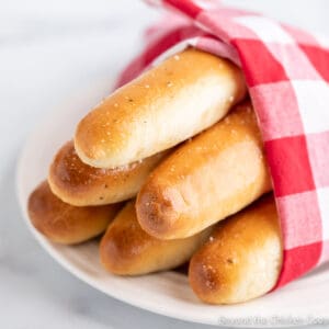 A bundle of breadsticks wrapped in a red and white napkin.
