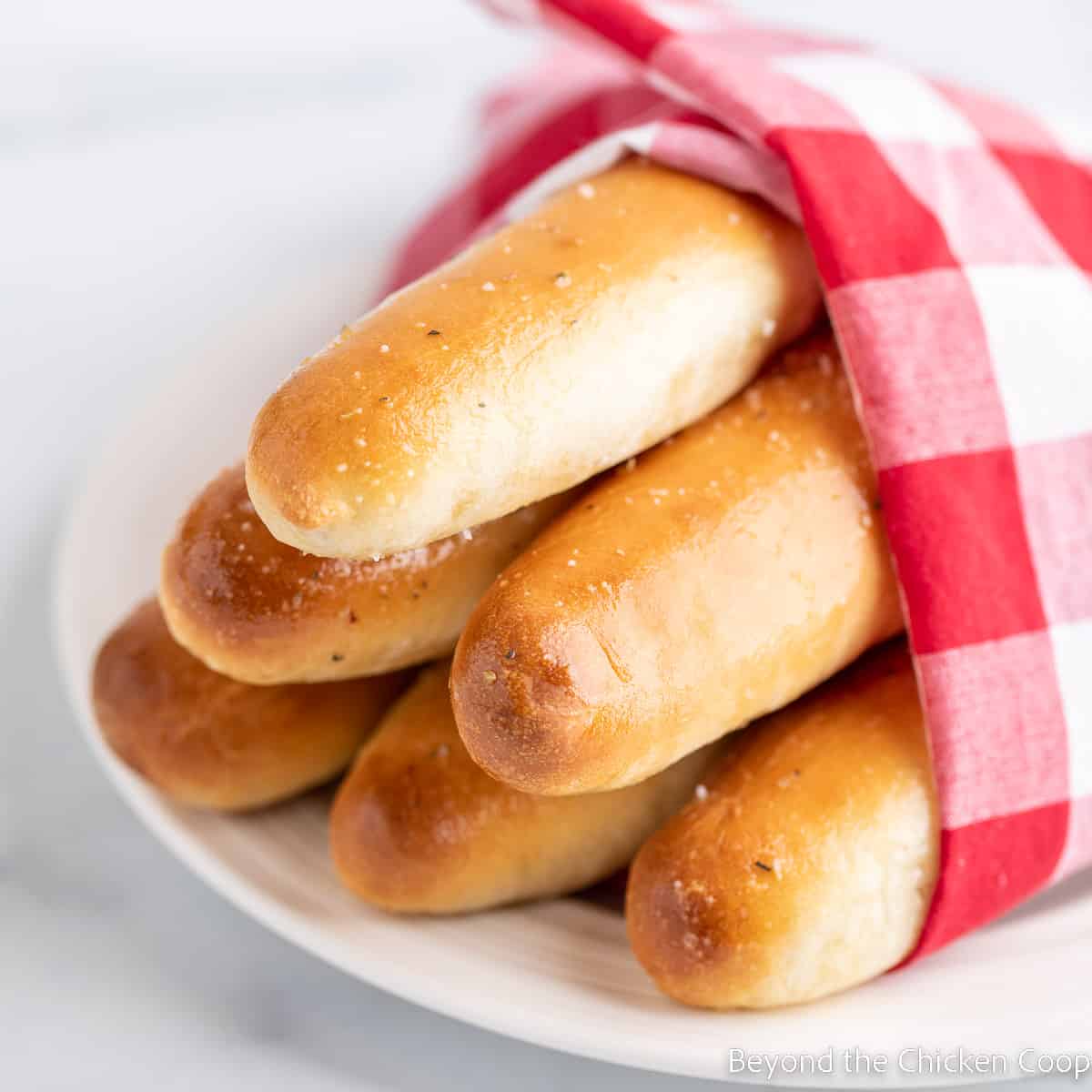A bundle of breadsticks wrapped in a red and white napkin.