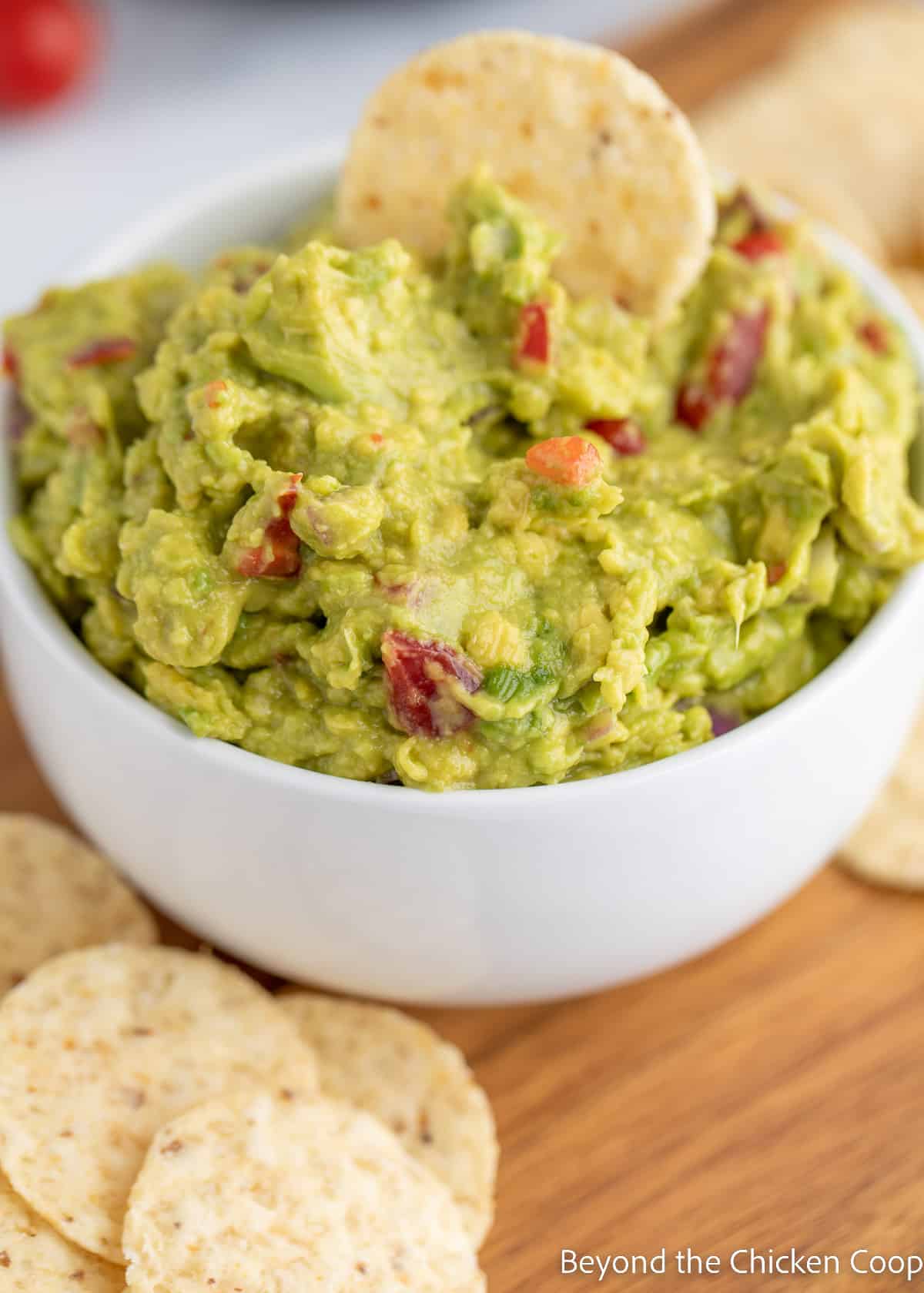 A white bowl filled with guacamole. 