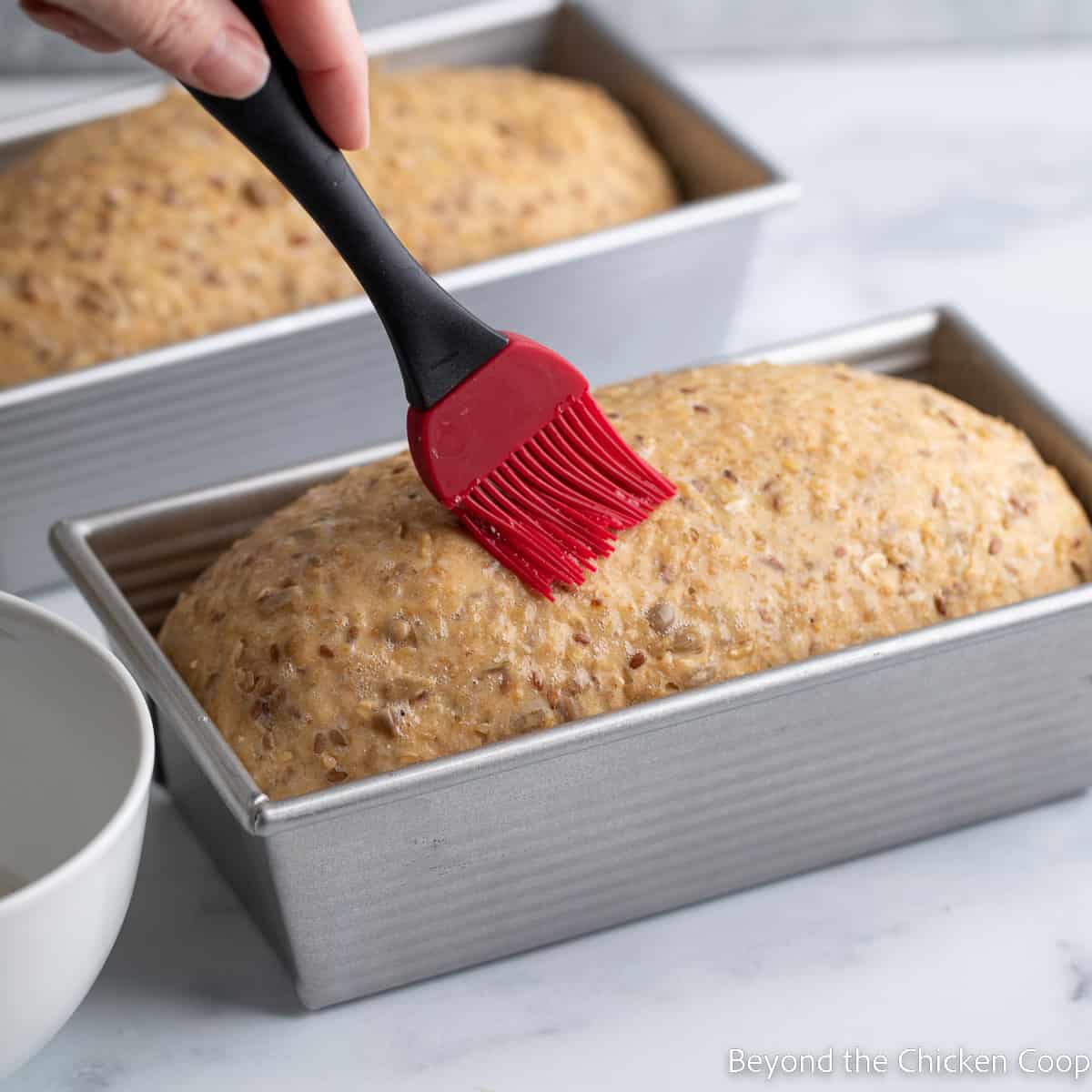 Brushing a unbaked loaf with egg white. 