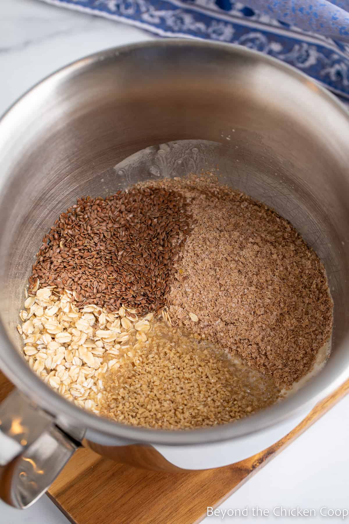 Adding flax seeds, oats and wheat germ to a mixing bowl. 