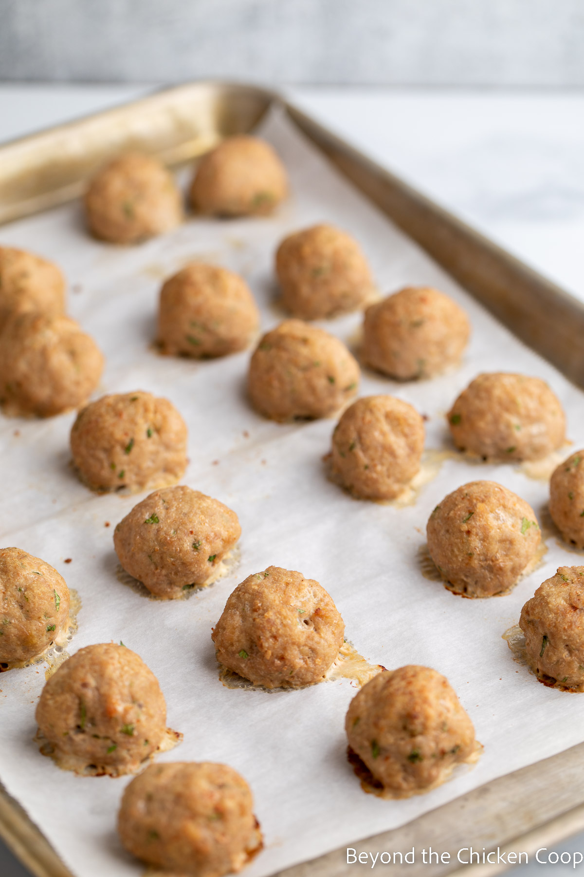 Baked meatballs on a baking sheet. 