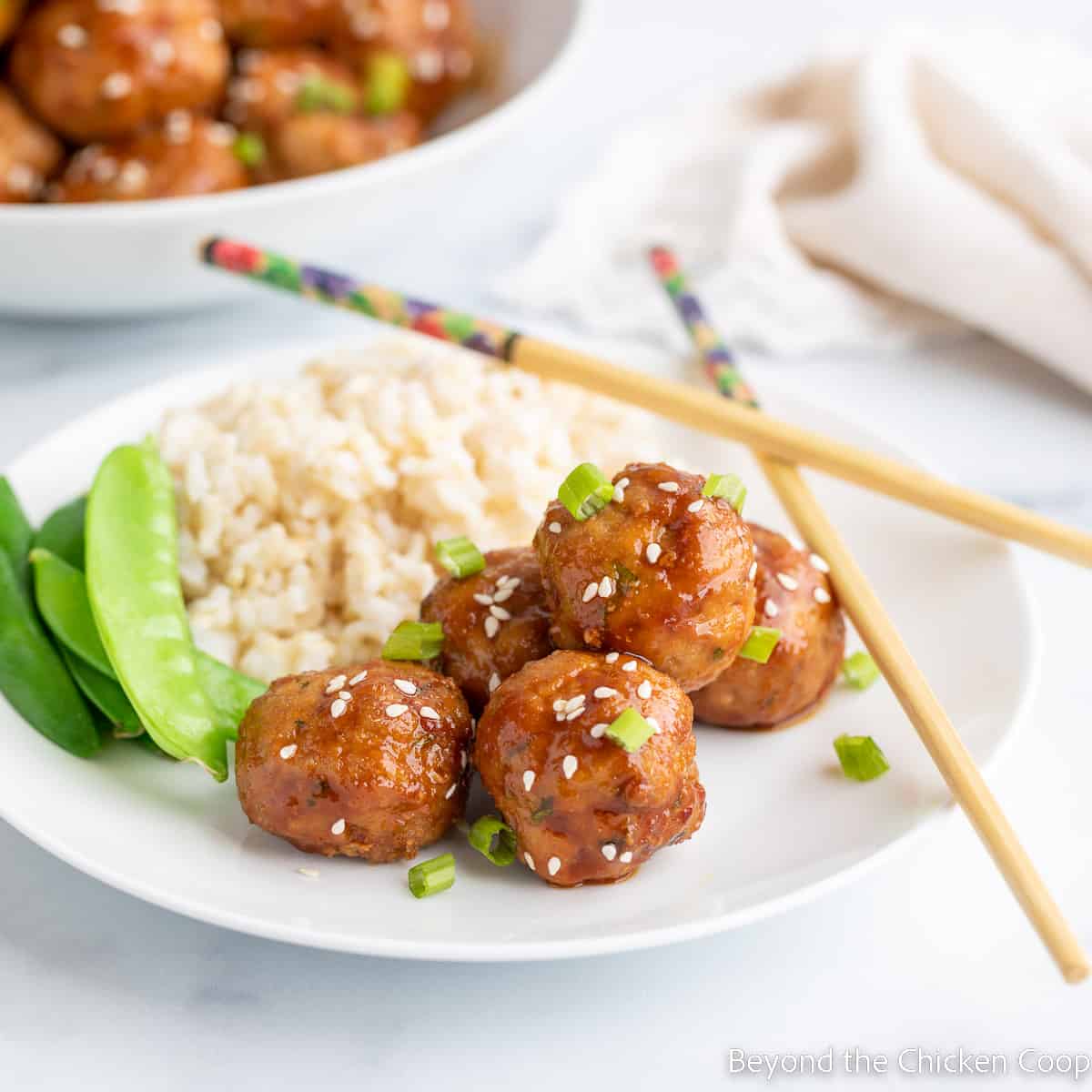 Meatballs on a plate with rice and peas. 