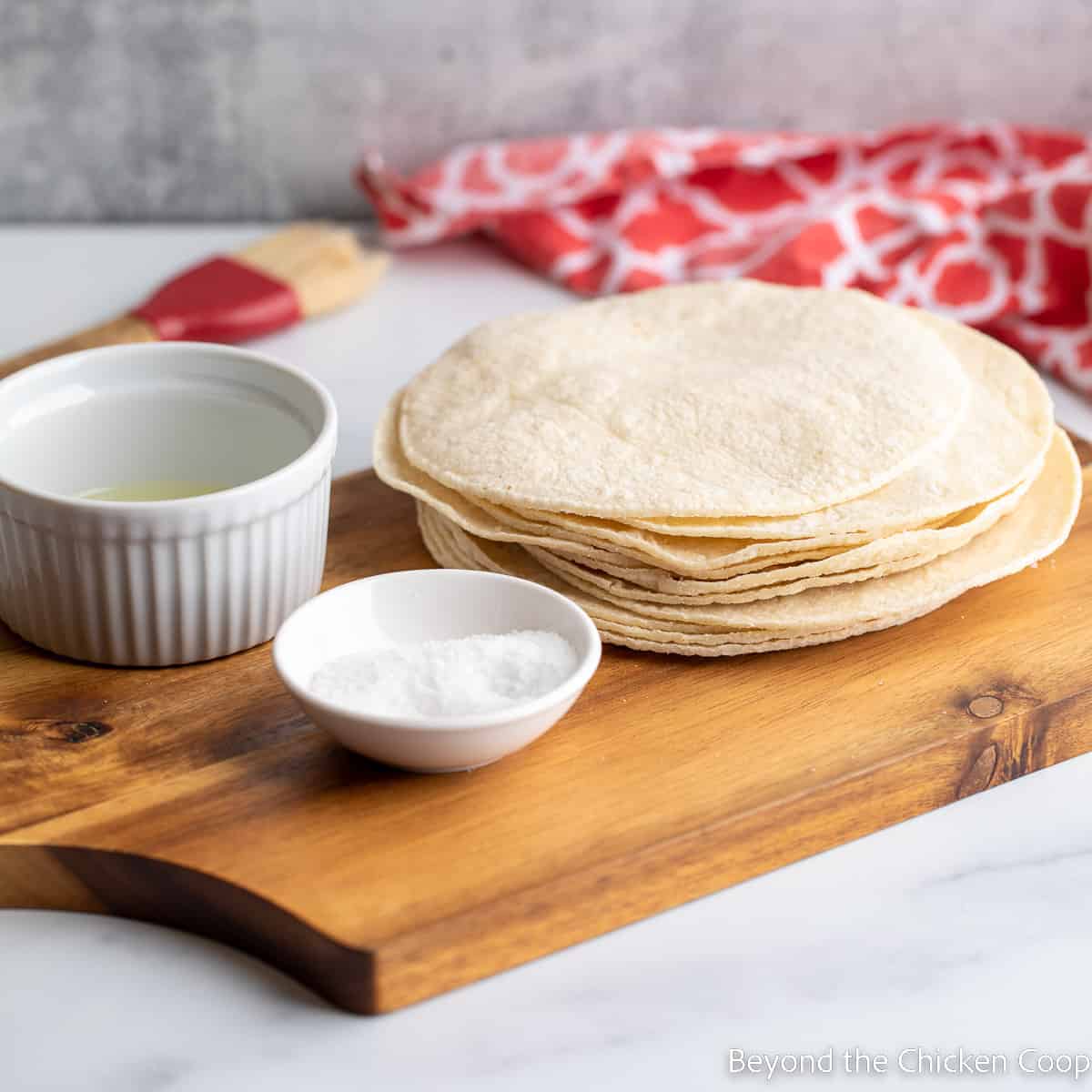 A stack of tortillas on a cutting board.