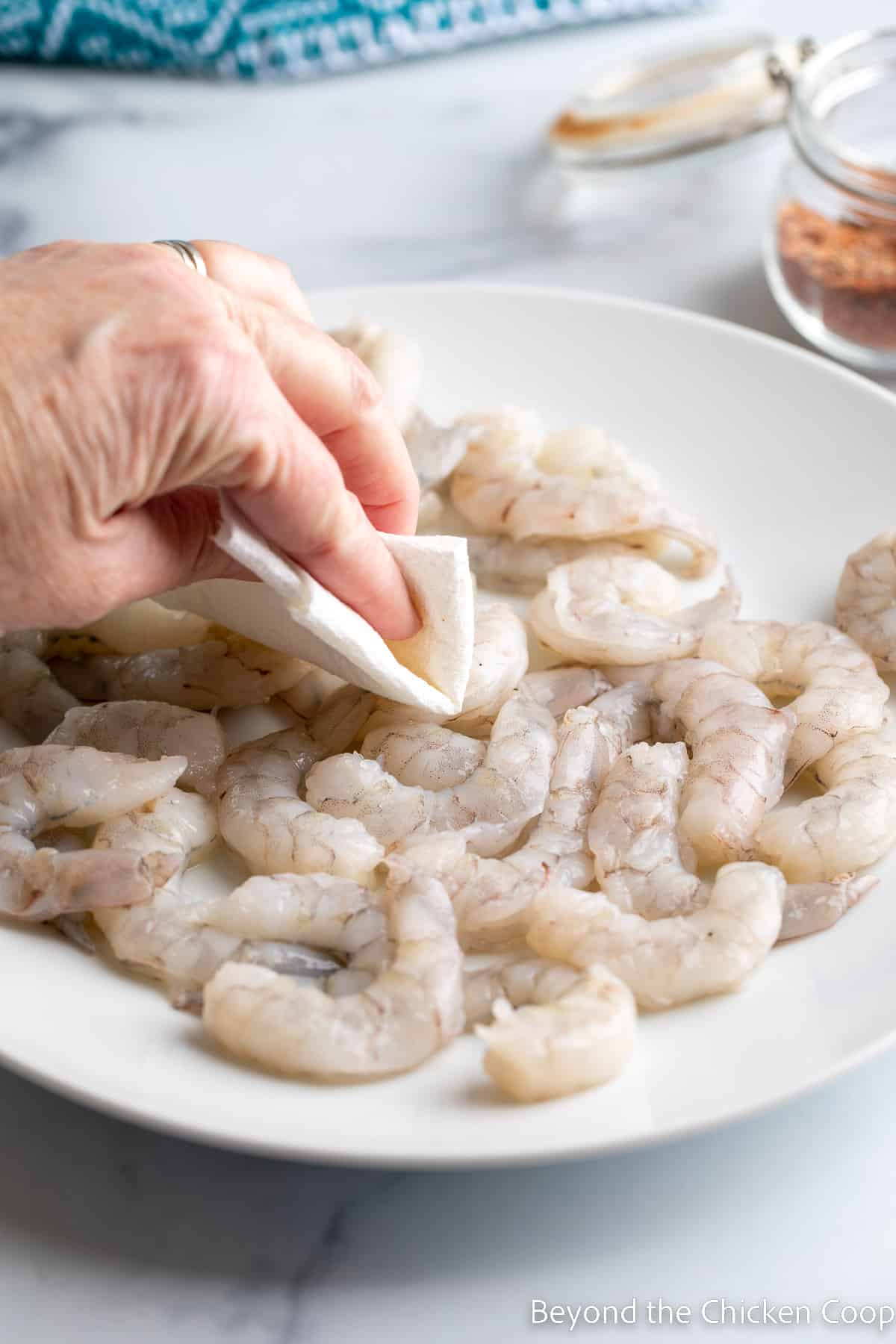 Patting shrimp dry with a paper towel. 