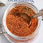 Seasoning in a jar with a spoon.
