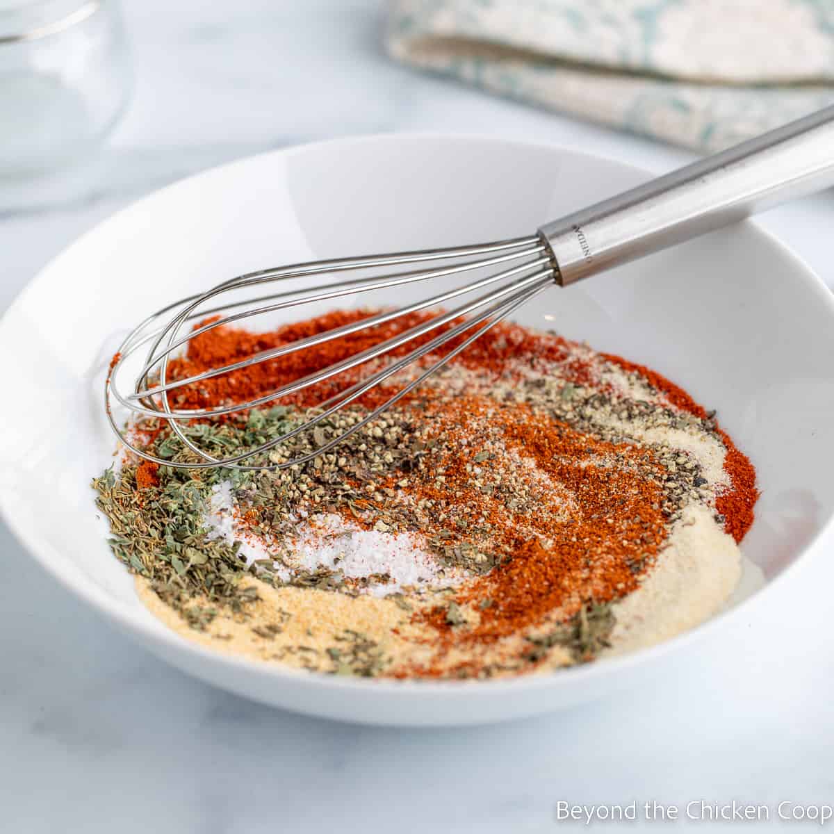 Spices being mixed together with a whisk. 