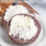 A bagel with cream cheese on a small white plate.