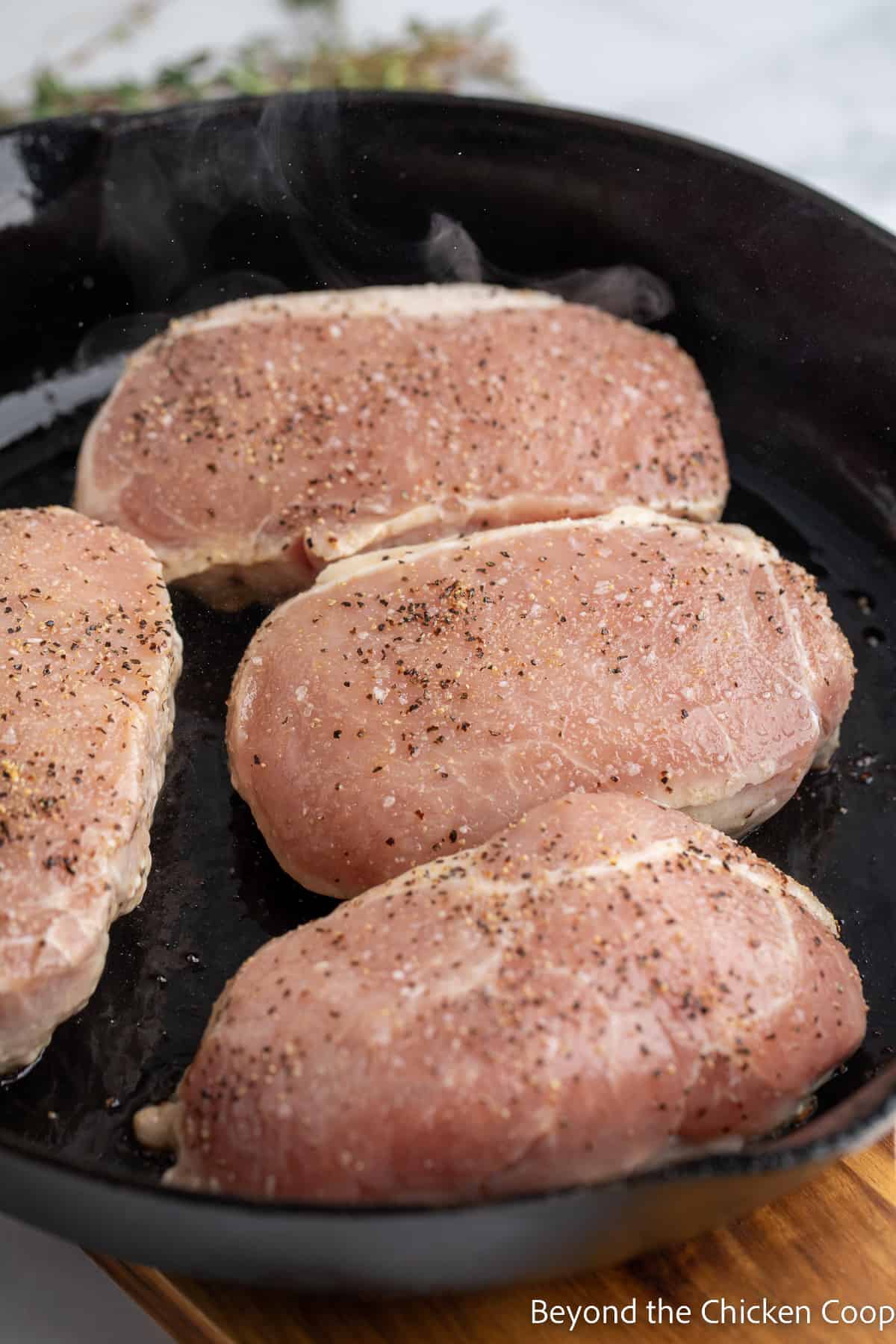 Pork chops in a cast iron skillet. 