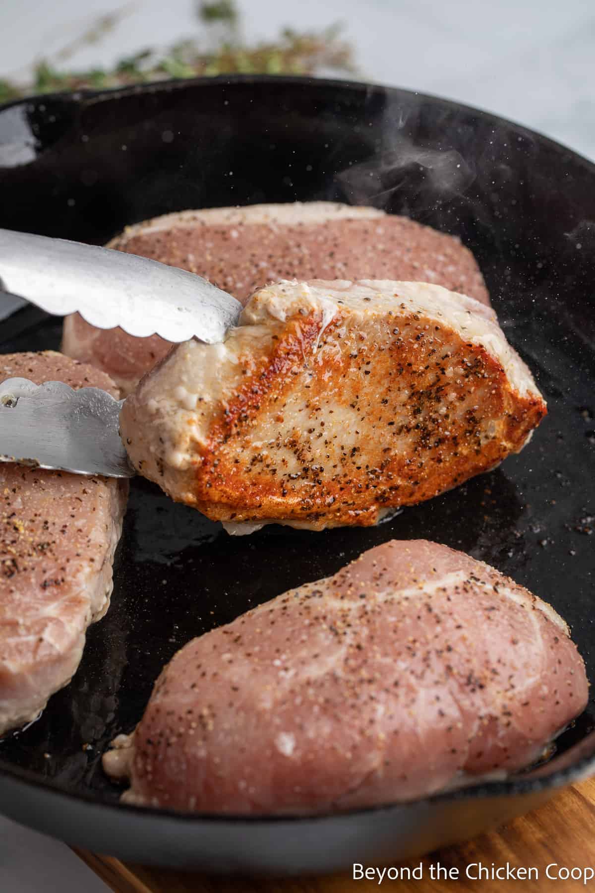 Checking the bottom of a seared pork chop. 