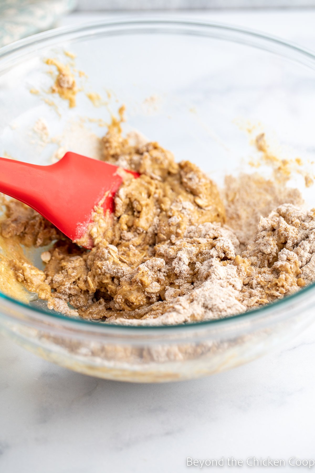 Mixing muffin batter in a glass bowl. 