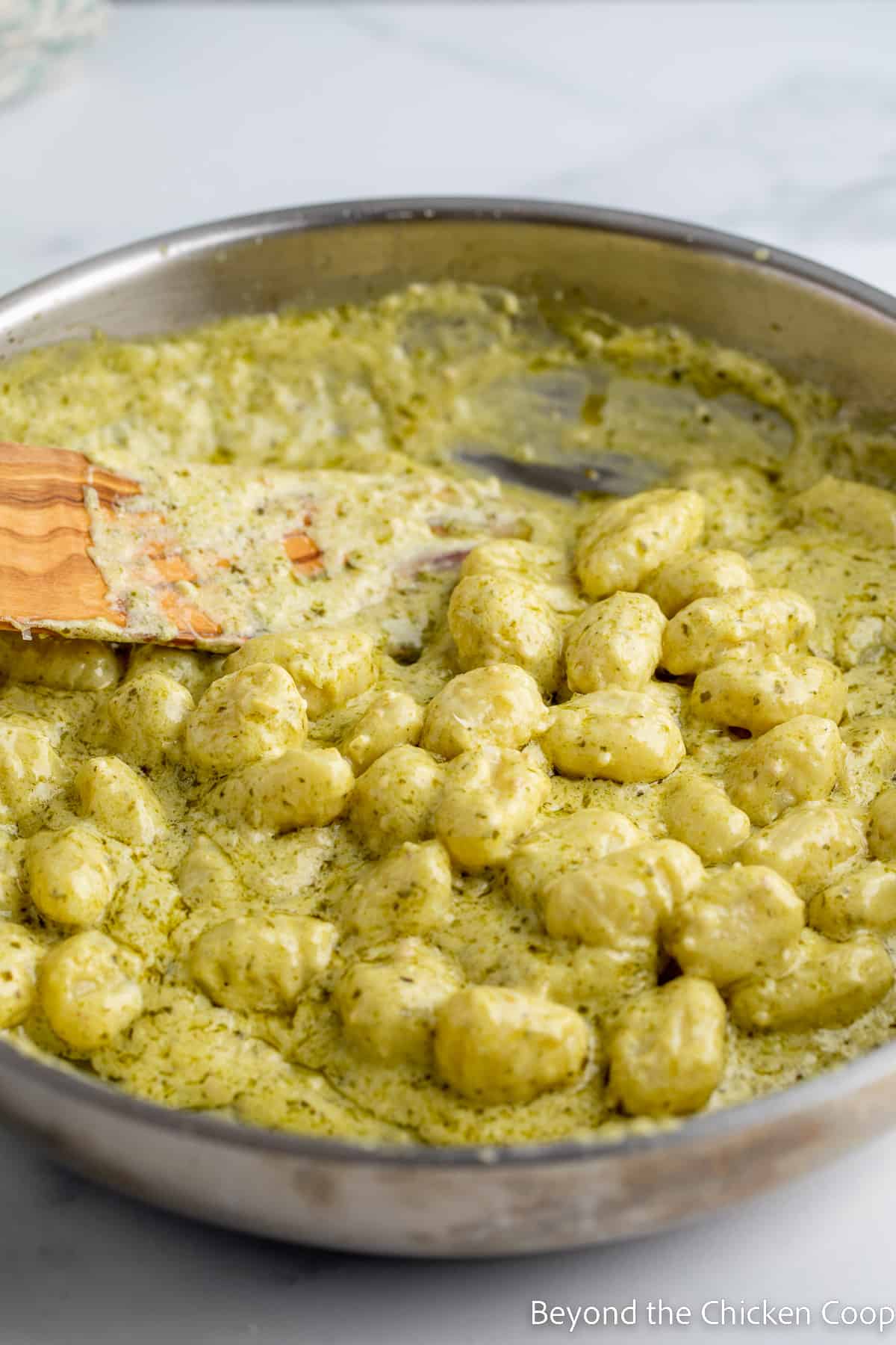 Gnocchi with pesto in a large saute pan.