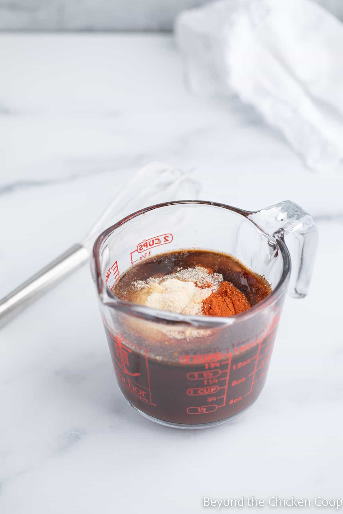 BBQ sauce and seasoning in a measuring cup. 