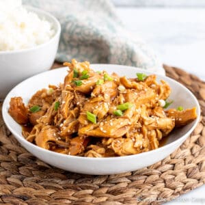 A white bowl filled with teriyaki chicken.