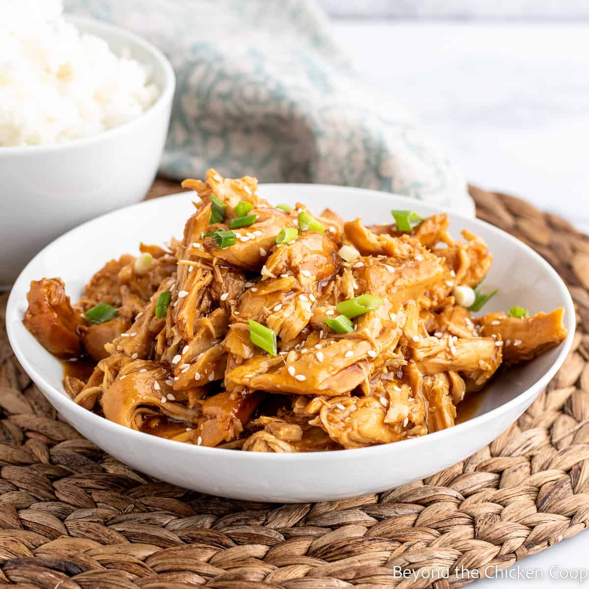 A white bowl filled with teriyaki chicken.