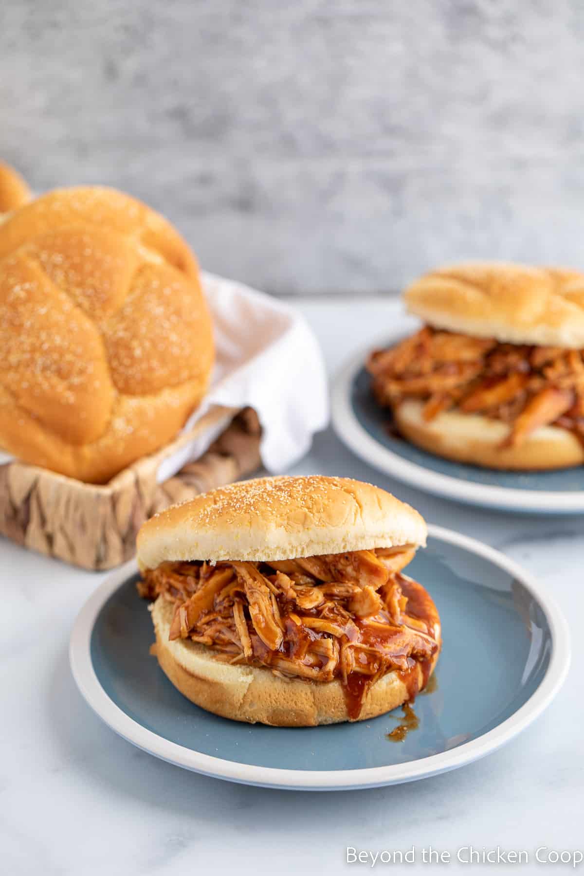 A shredded bbq chicken sandwich on a blue plate. 