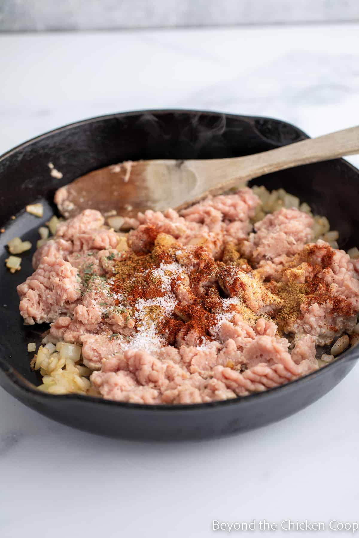 Seasoning sprinkled over raw burger.