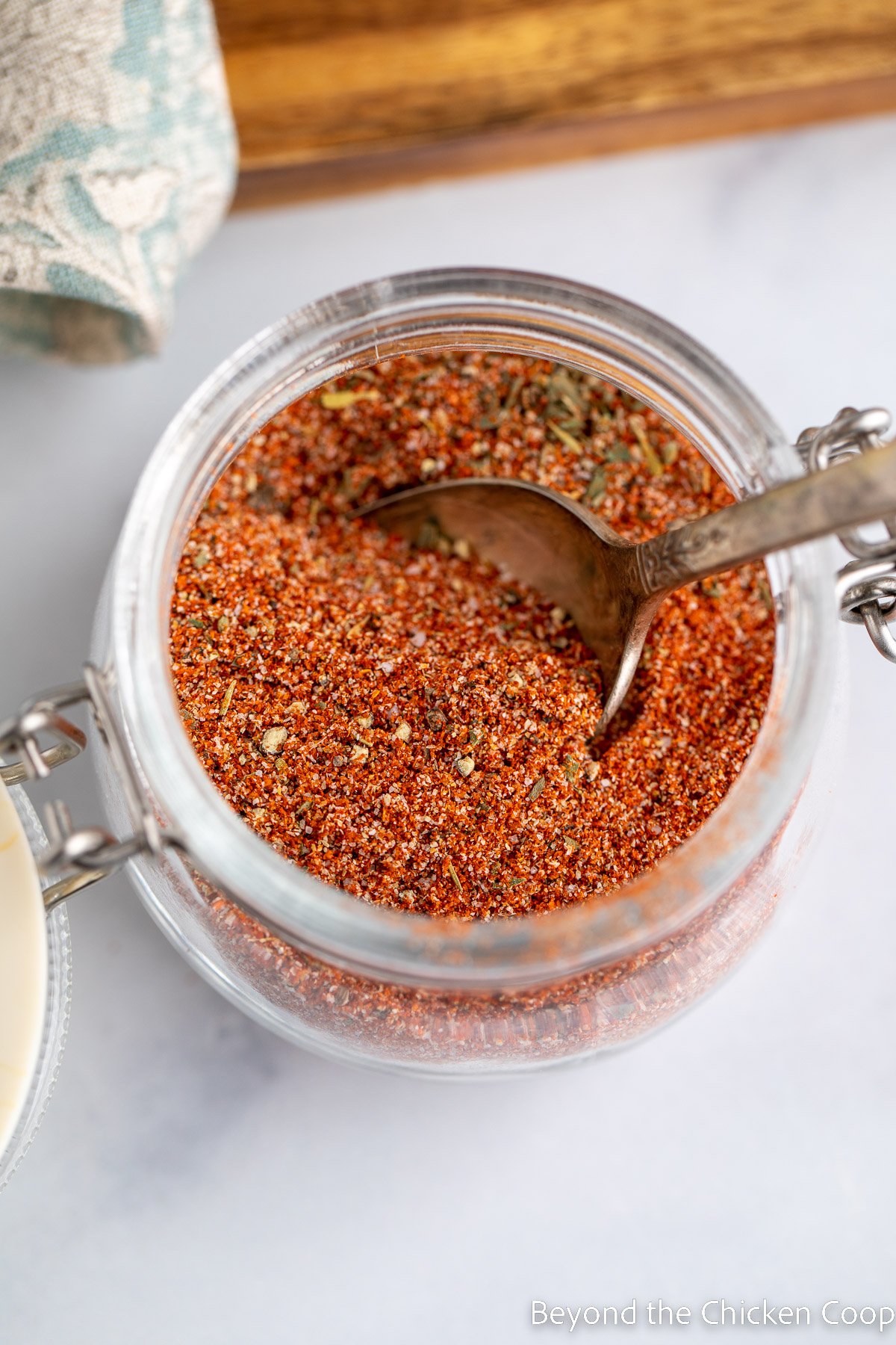 A spice jar with a spoon inside the jar. 