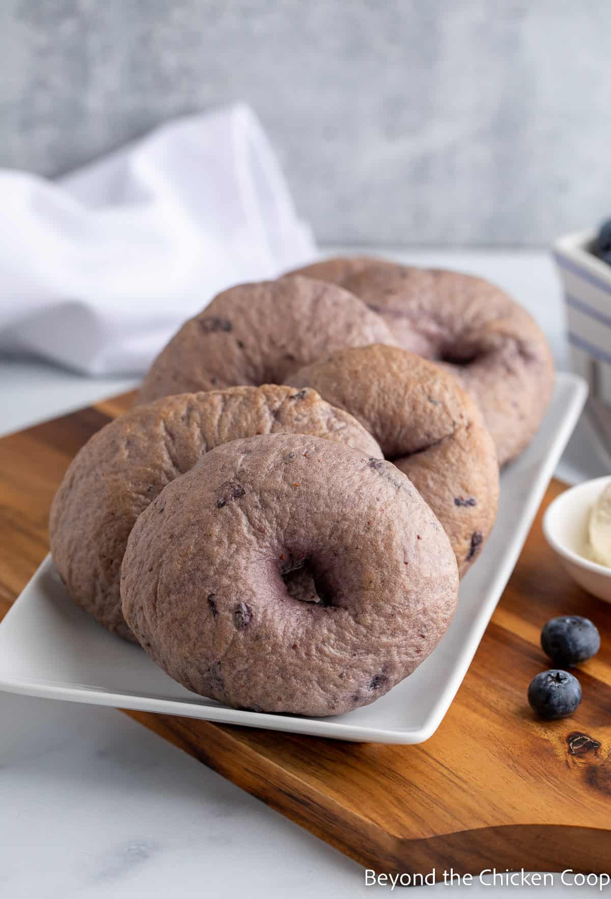 A white plate filled with bagels. 