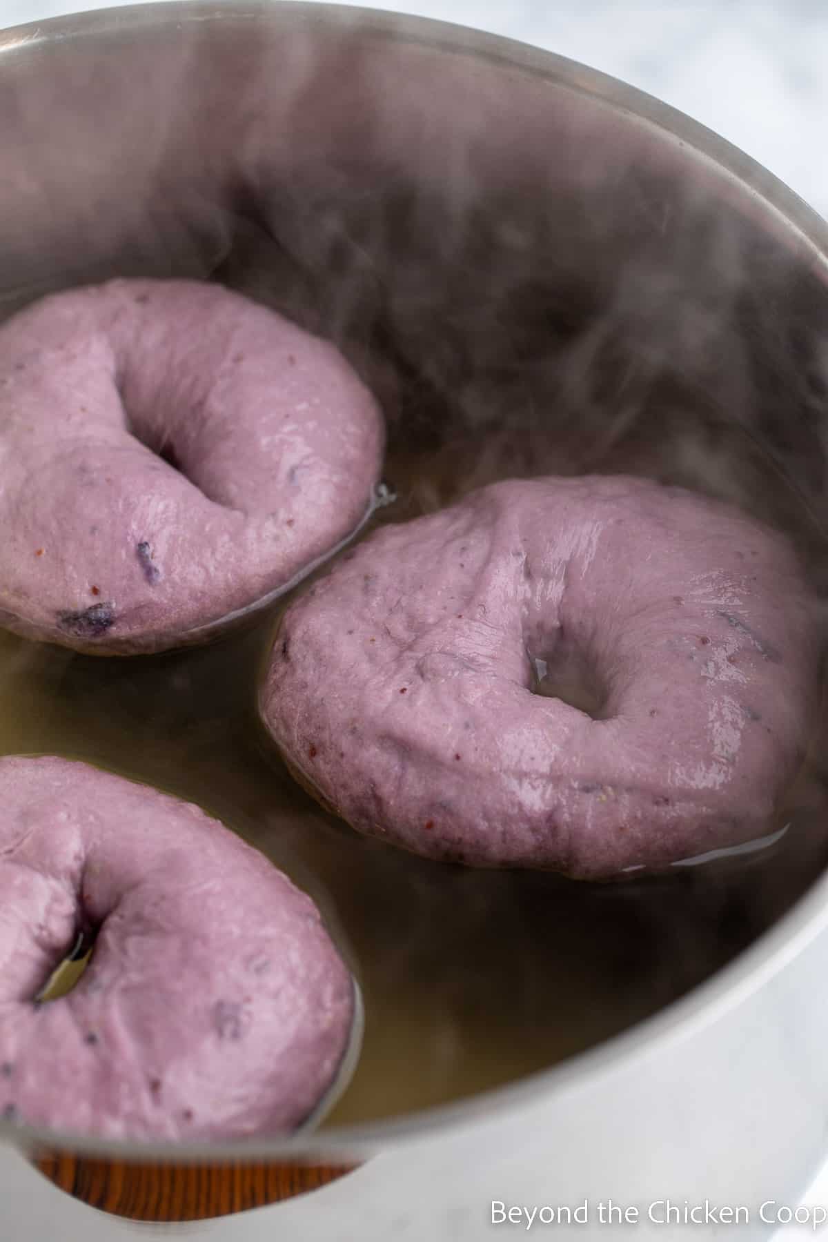 Boiling bagels in a water bath.