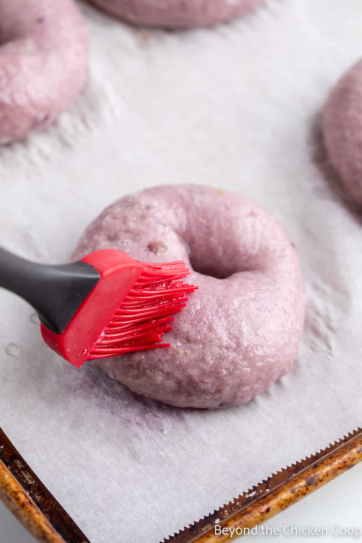 Brusing a bagel with an egg wash. 