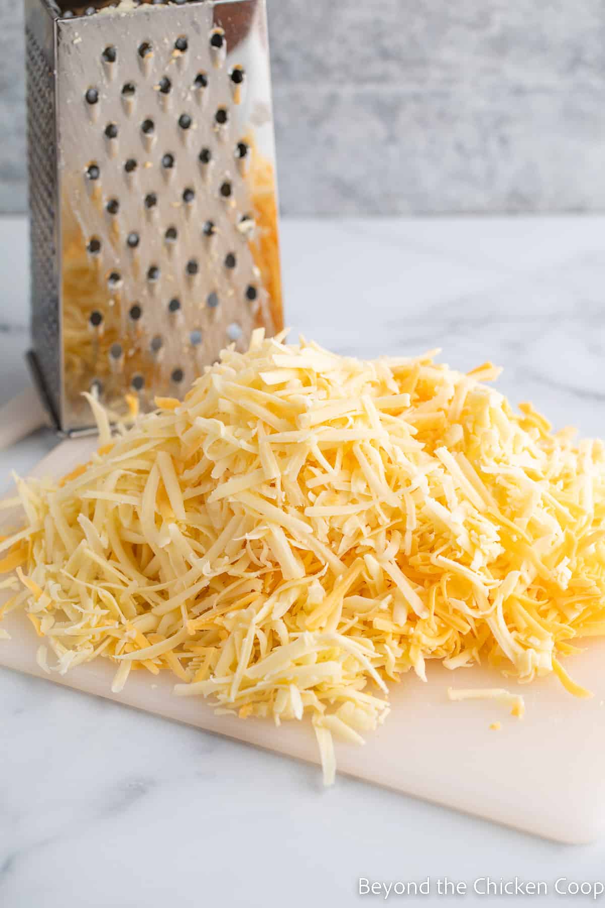 Shredded cheese on a cutting board. 