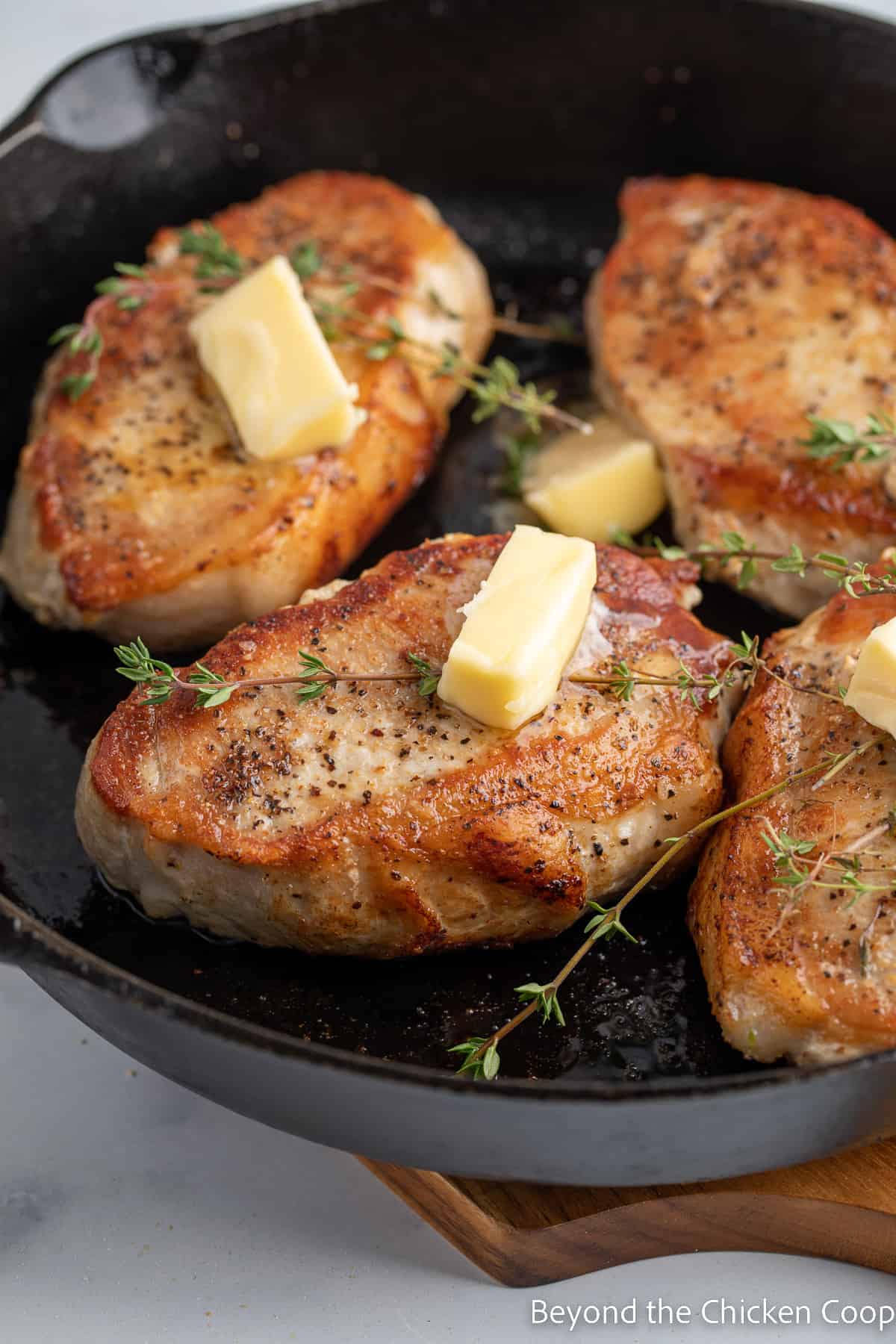 Pats of butter on top of cooked pork loin chops. 