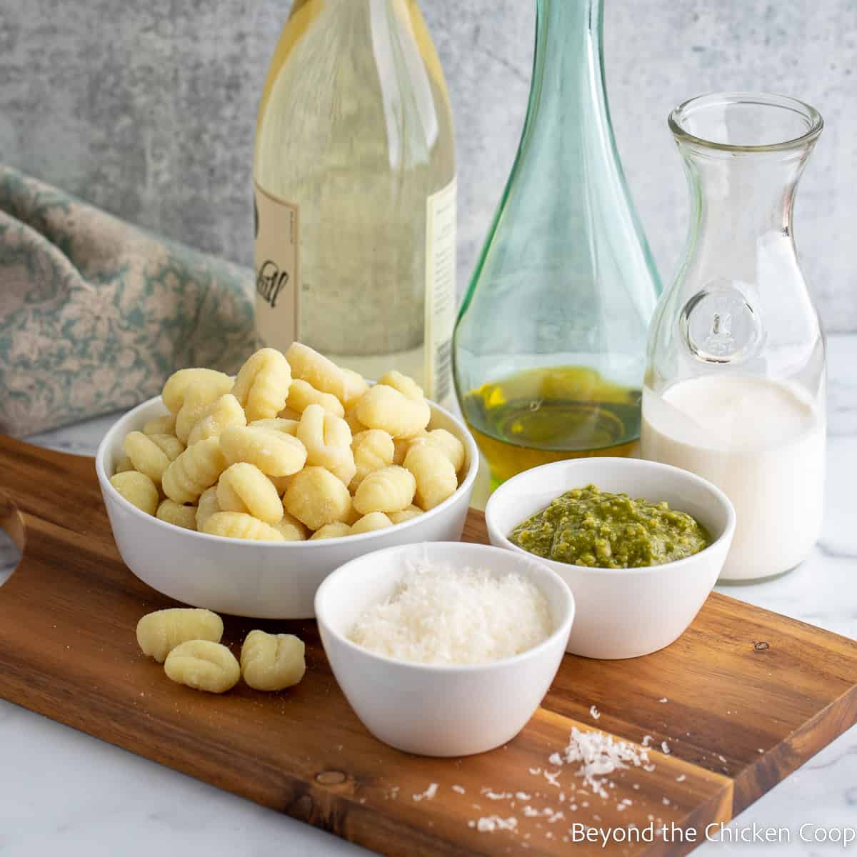 Small bowls filled with pesto, gnocchi and parmesan cheese. 