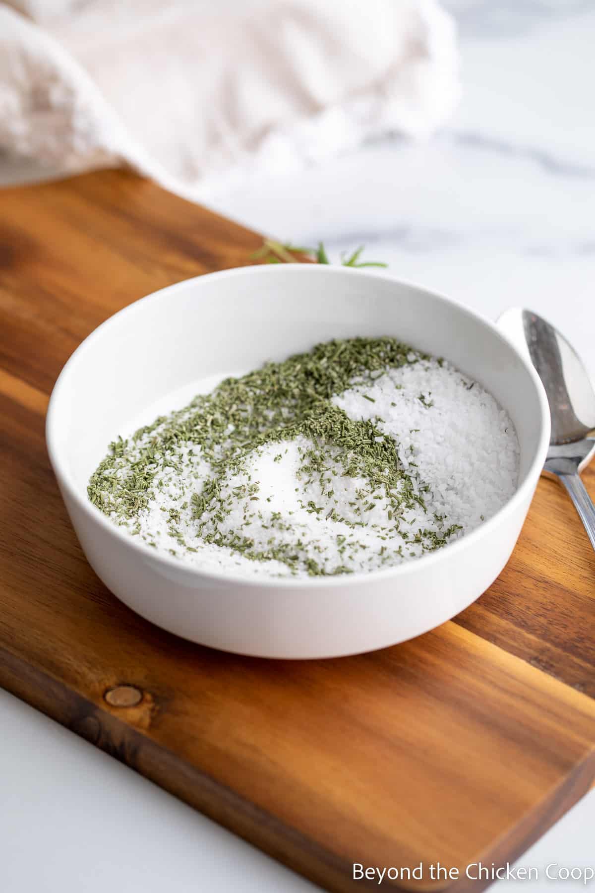 A bowl with salt and dried rosemary. 