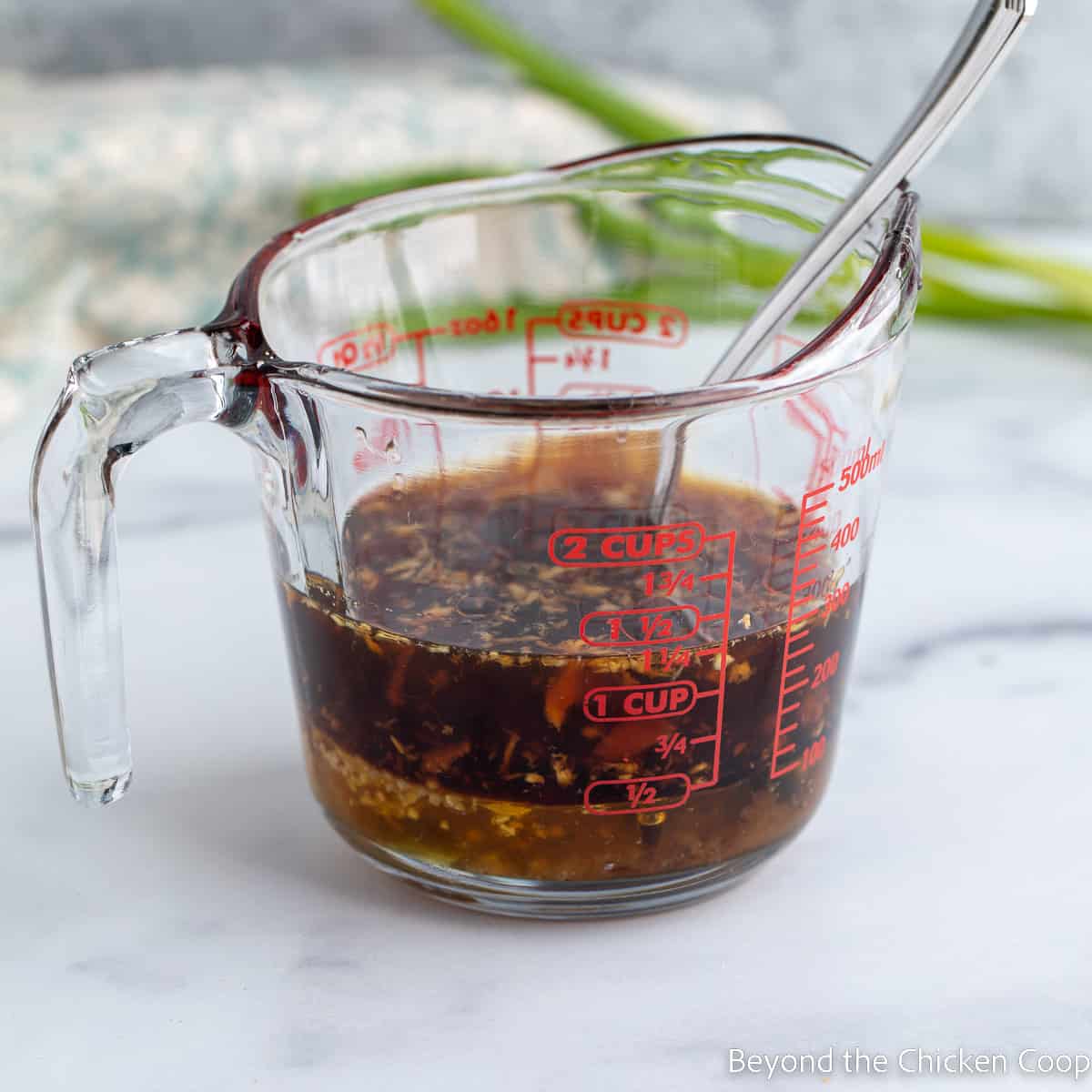 Teriyaki sauce in a glass measuring cup. 