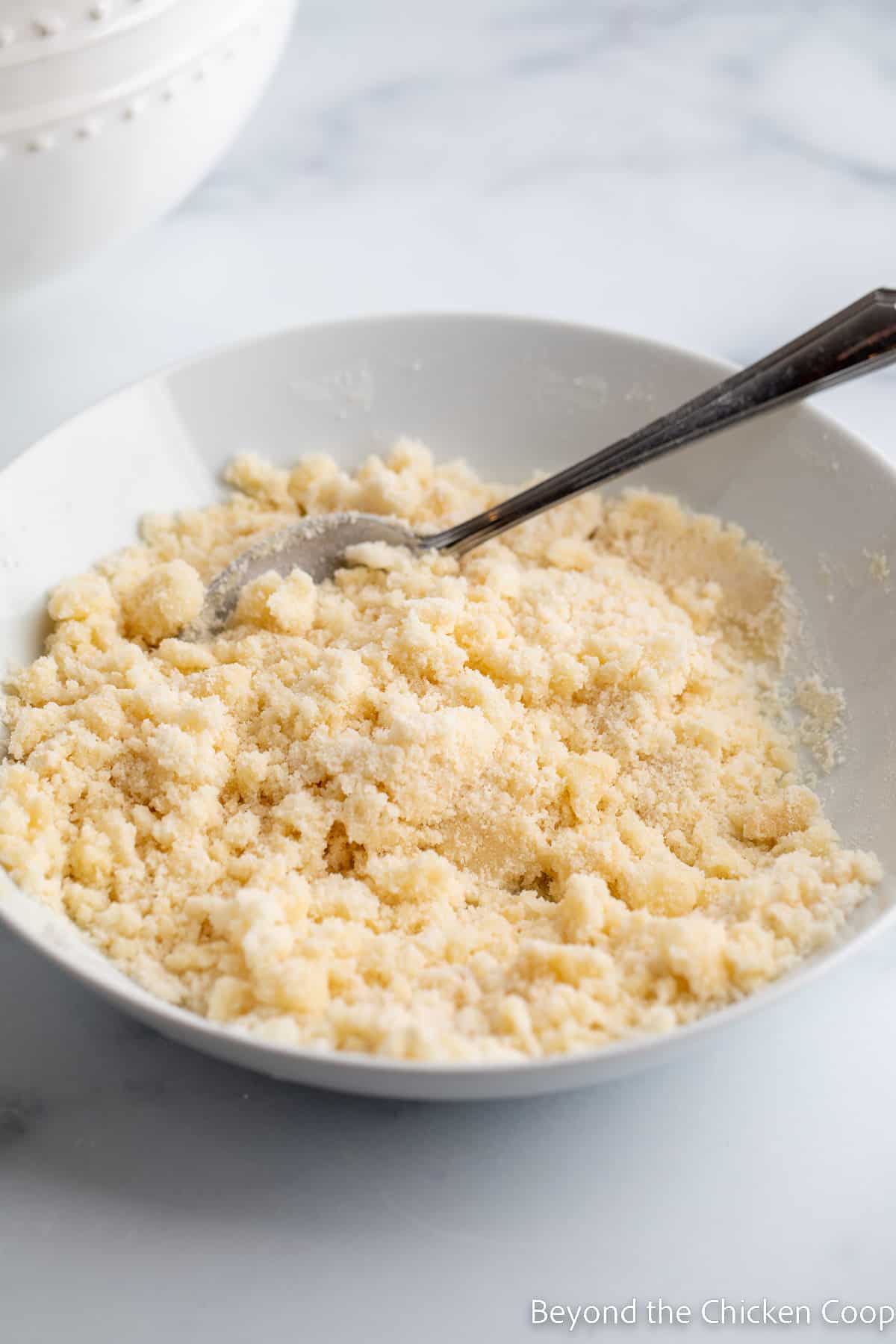 Crumbly topping in a white bowl. 