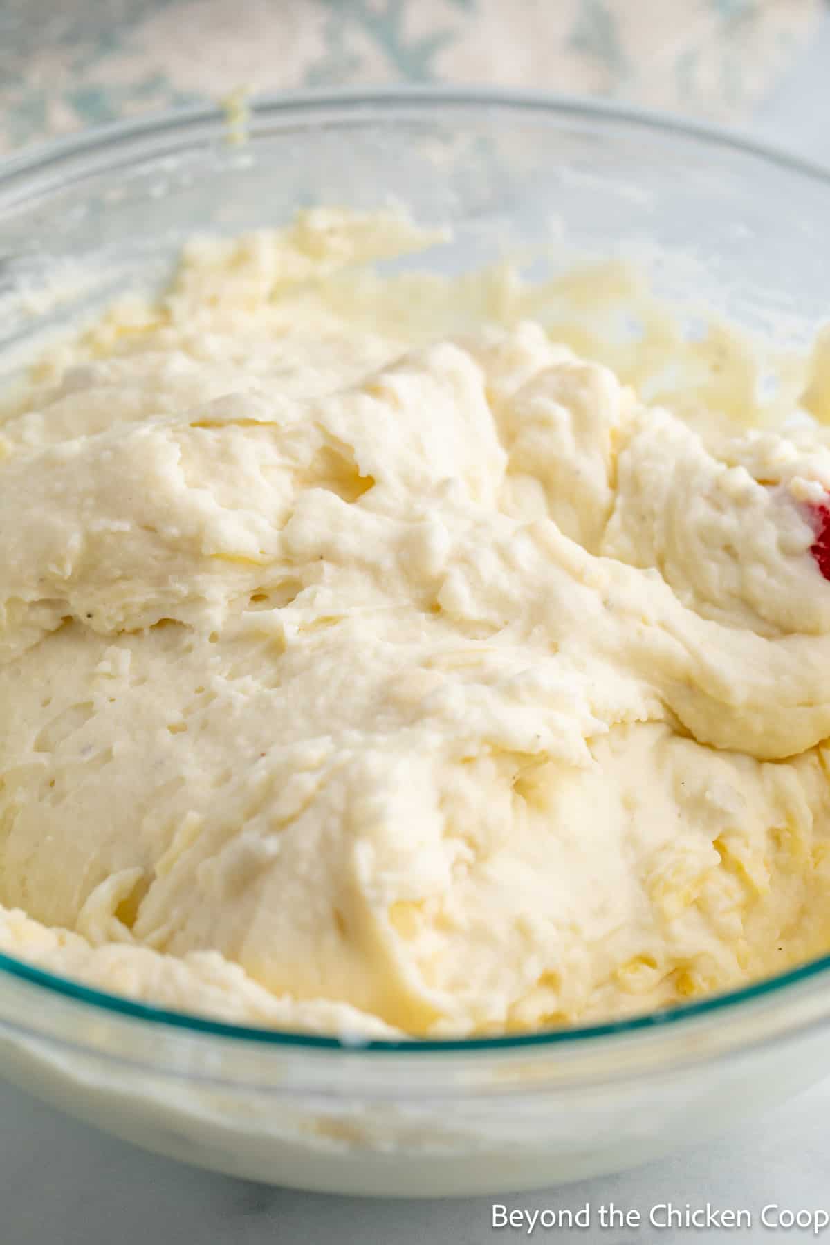 A glass bowl filled with mashed potatoes. 