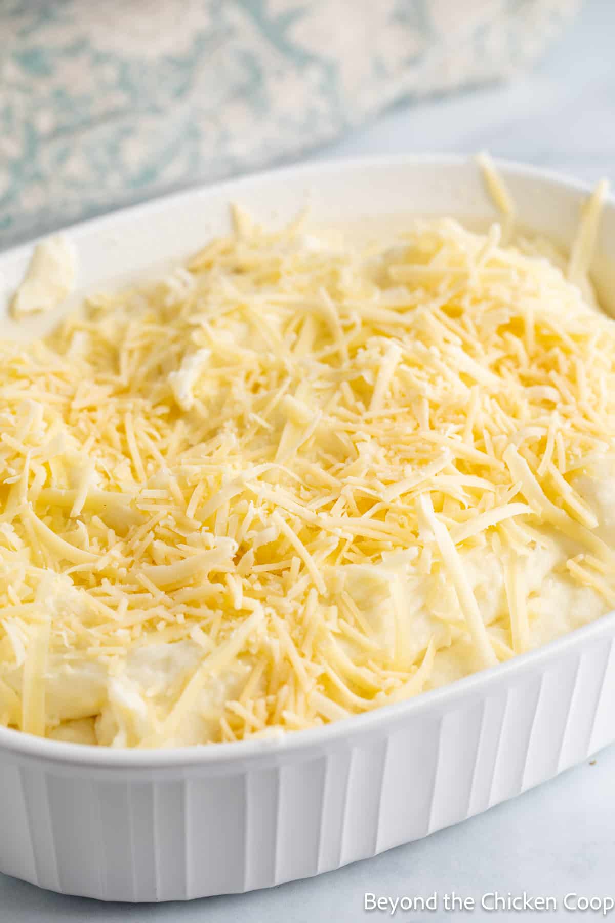 Shredded cheese on top of mashed potatoes. 